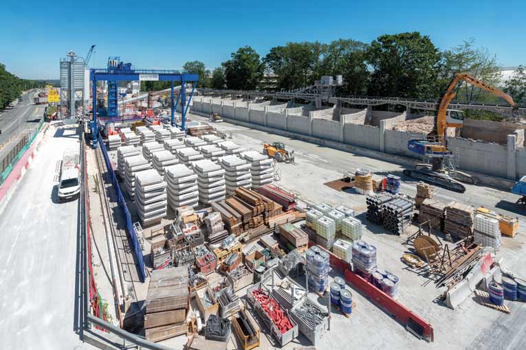 Le tunnel est creusé à partir du puits de départ OA 802, situé au pied du pont roulant de couleur bleue. Au premier plan, les voussoirs nécessaires à la construction. [©ACPresse]