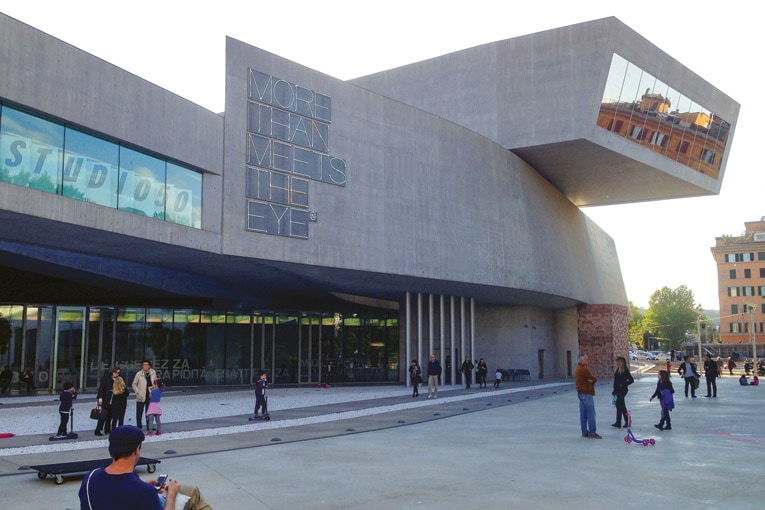 Le MAXXI se trouve à l’intérieur de la grande œuvre architectonique aux formes novatrices et spectaculaires imaginée par Zaha Hadid dans le quartier Flaminio de Rome. Avec ses 27 000 m² environ, l’ensemble s’intègre dans le tissu de la ville et constitue un nouvel espace urbain ouvert, articulé et “perméable” au passage. [©Wikipédia]