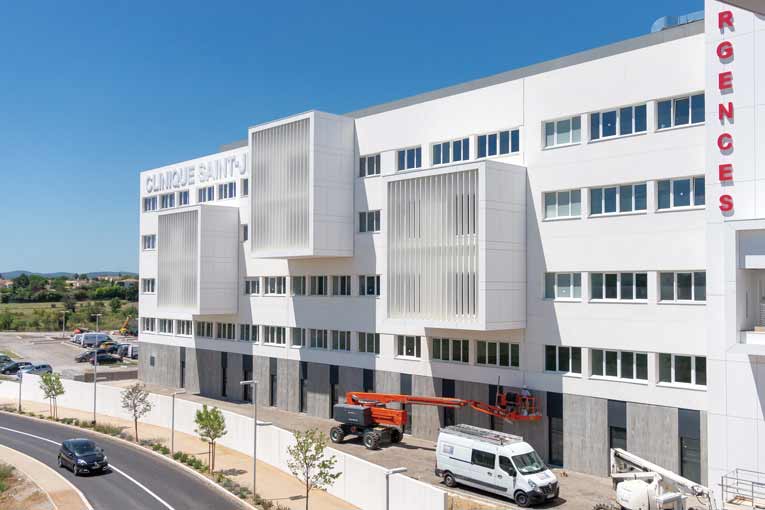 Les façades en béton blanc sont posées sur un socle en béton gris matricé. [©ACPresse]