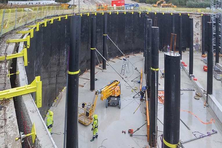 Les prédalles sont positionnées à la verticale, le long de la paroi moulée, laissant un interstice qui sera rempli de béton. Et toute la surface du bassin reçoit les poteaux porteurs de la dalle de couverture.  [©Agru]