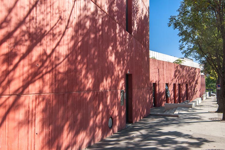 La teinte rouge des bétons de ce stade de tennis, à Paris, renvoie à la couleur des briques utilisées pour la construction des immeubles bordant les boulevards des Maréchaux. [©ACPresse]