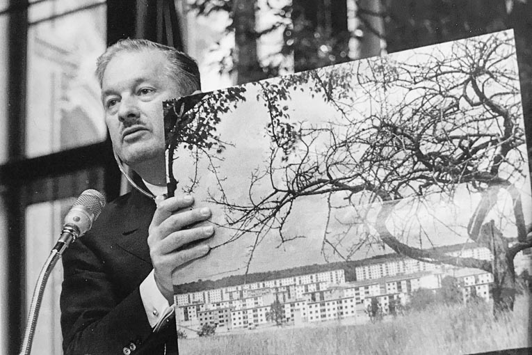 Raymond Camus présente à Vienne ses procédés de préfabrication. Il tient entre se mains la photo de la cité Barhen construite pour les houillères du bassin de Lorraine. [©Archives Michel Camus]