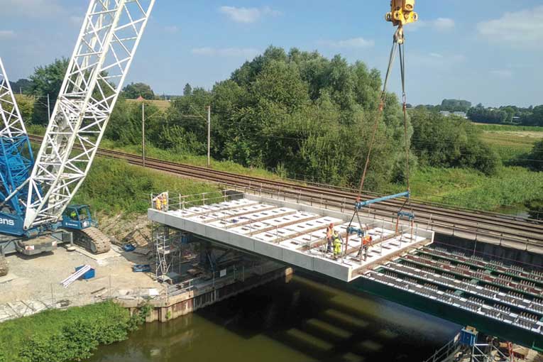 Mise en place des dalles préfabriquées par Capremib sur le pont ferroviaire enjambant la Sambre, à Sassegnies. [©Capremib]