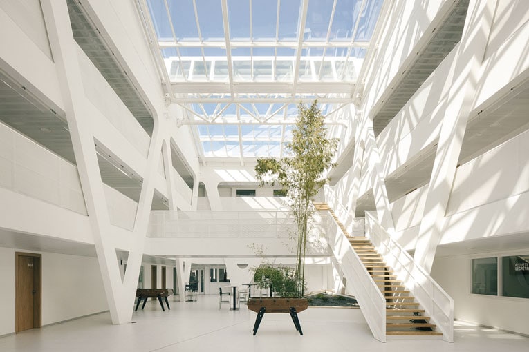 Une structure composée de “V” porte l’atrium et tous les planchers alvéolaires latéraux. Cela permet de libérer complètement l’espace. [©Charly Broyez/Alta architecture]