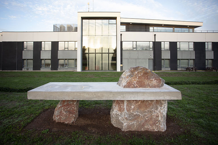 Comme un bug dans la réalité, un dysfonctionnement, une roche se retrouve piégé dans un mur. Situé entre l'artefact et le mobilier, Fusion permet au cours de s'approprier les structures. 
Fusion, enrochements et béton, 3,50 x 1,10 x 1,60 m, lauréats 2022 : Coline Miossec et Timothé Orloff, Haute-école des arts du Rhin, Mulhouse, Collection Prima 2022. [©Groupe CB/Prima par Nicolas Guiraud]
