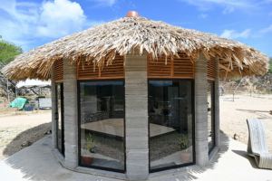 La première maison imprimée en 3D béton au Guatemala associe une technique de construction moderne à un toit type “Rancho” en feuilles de palmier traditionnel. [©Cobod]