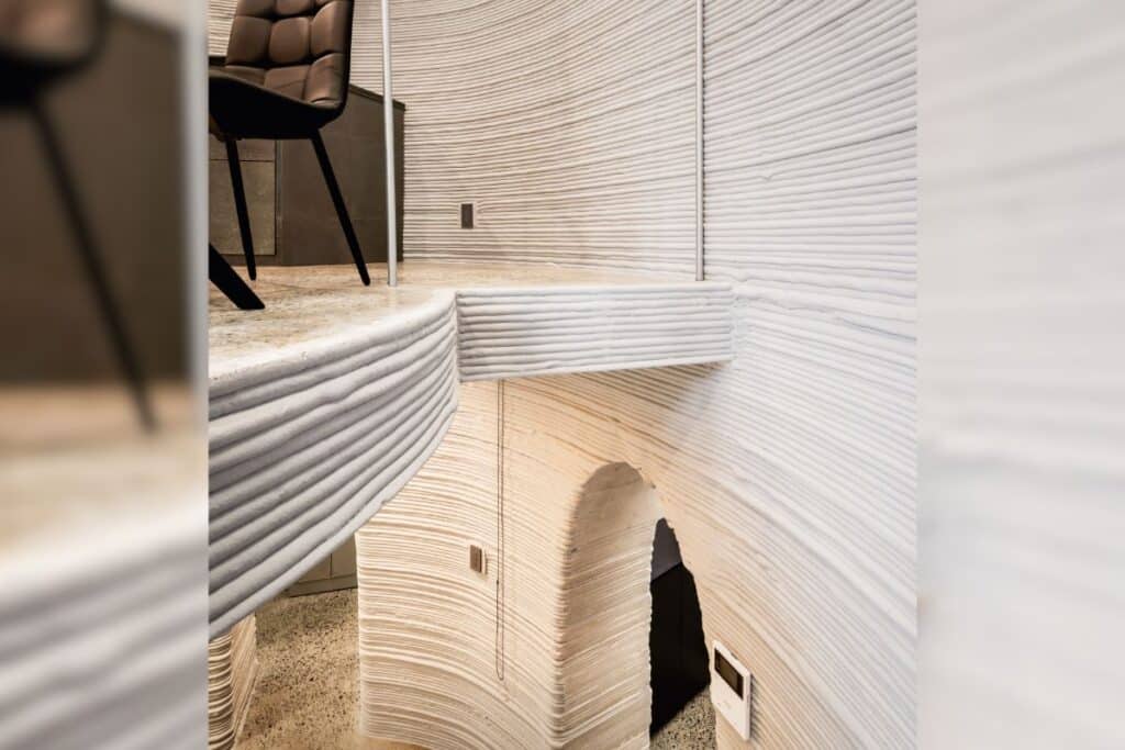 Dalle de plancher imprimée en 3D intégrée à la conception structurelle et architecturale, renforçant la géométrie courbe continue de l’ensemble du bâtiment. [©Cobod]