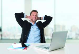 attractive businessman happy at work smiling relaxed at computer